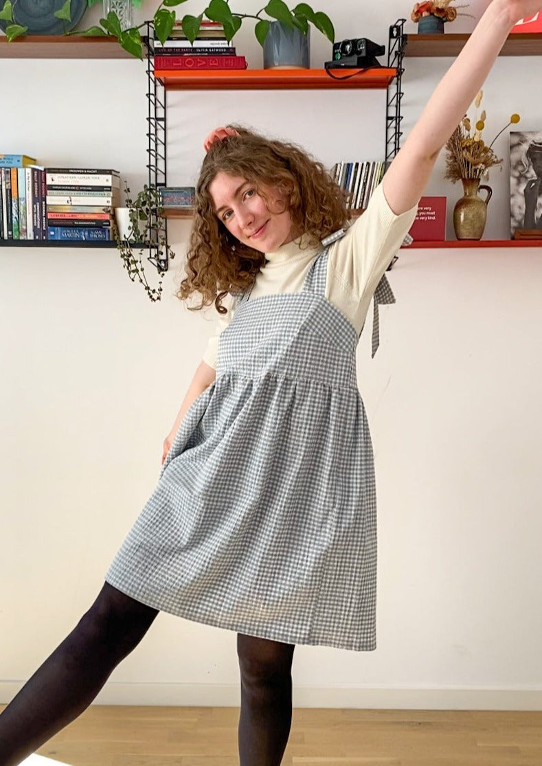 Picture of Leen, a twenty something white woman, posing in the Alice dress and smiling.