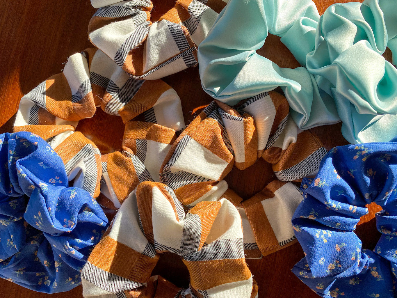 Collection of colorful scrunchies on a wooden surface